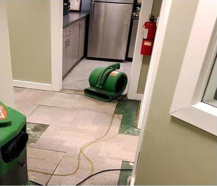 Air movers and dehumidifiers setup to restore water damage to Manhattan office kitchen