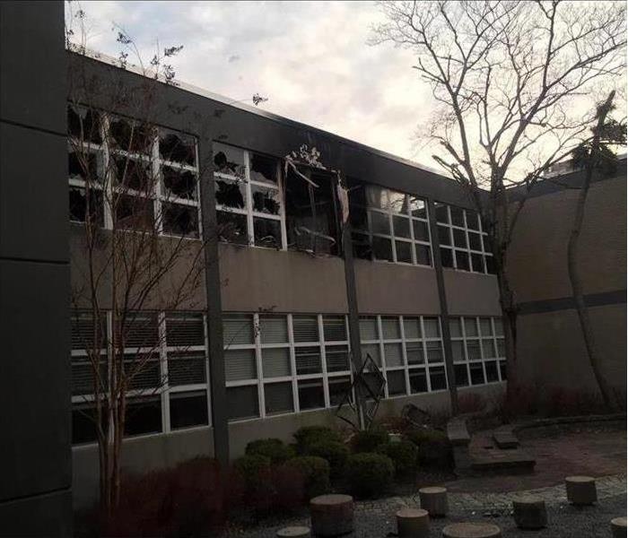 School exterior with fire damage including broken windows and smoke and soot damage